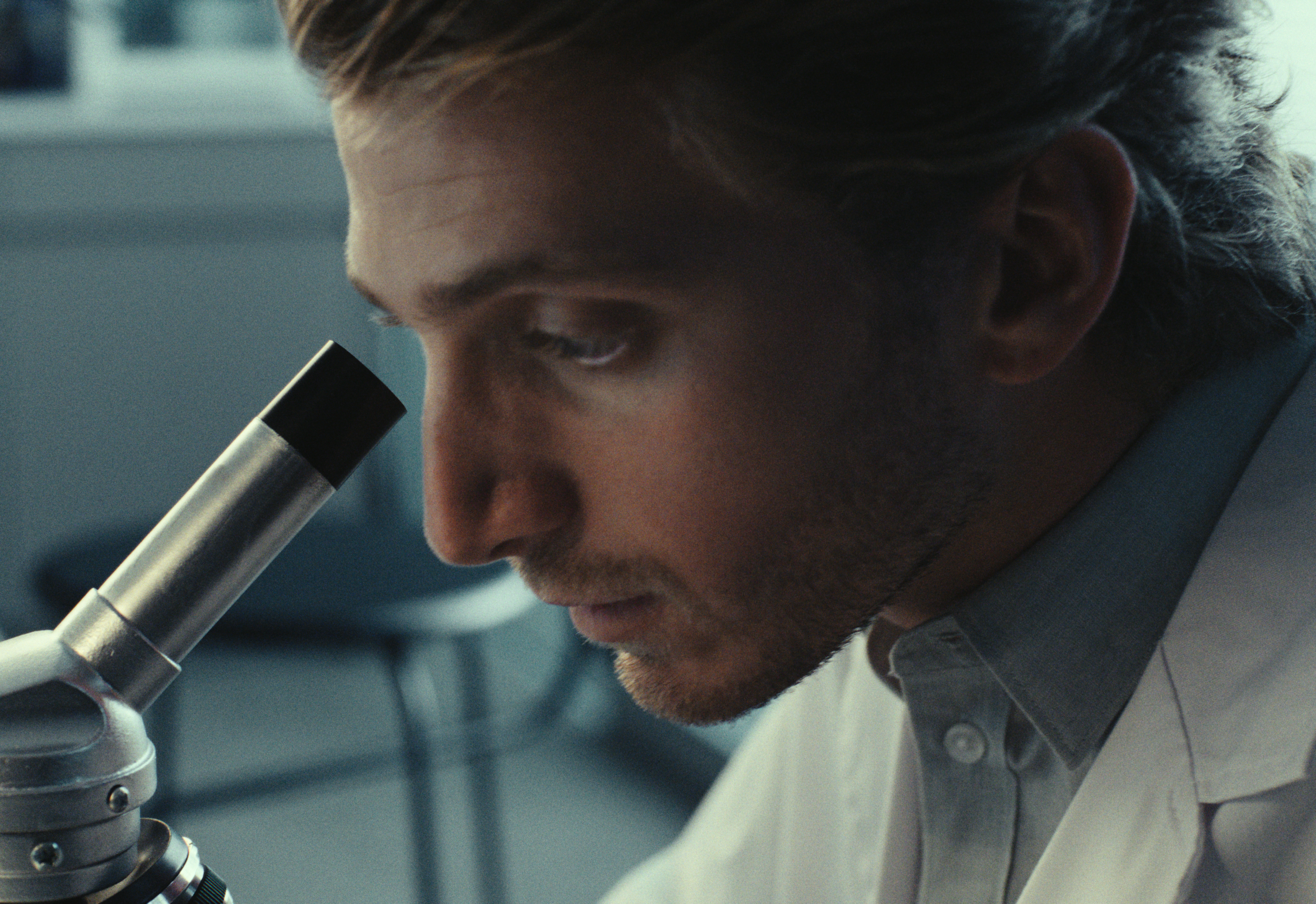 Scientist looking through a microscope.